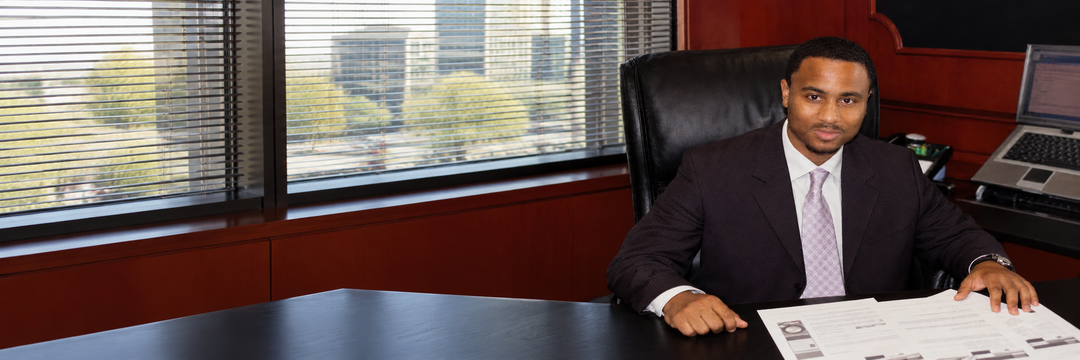 Justin W. Lee seated at his desk with business documents